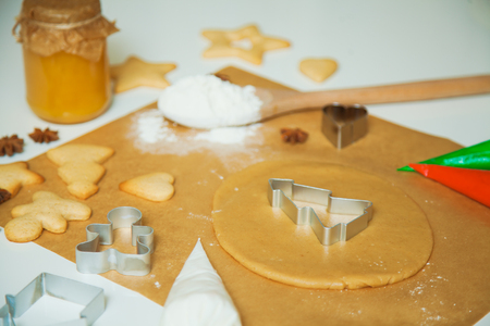Cooking Christmas gingerbread cookies decorating for new year celebration. Dough and cookie cutters on baking paperの写真素材