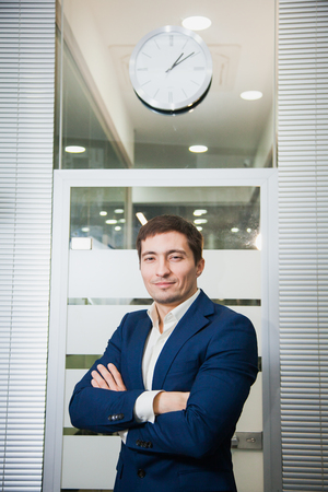 Handsome confident businessman with crosshands pose to camera. Male office worker. Business, success concept.の写真素材
