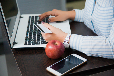 Online shopping, e-commerce, money transaction, internet business concept. Female businesswoman hold plastic credit card sit by laptopの写真素材
