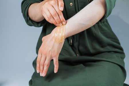 Tutorial hair removing sugaring, depilation, waxing. Closeup female hands using sugar paste. Beauty skin conceptの写真素材