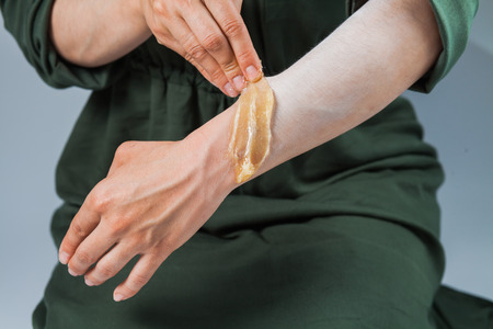 Tutorial hair removing sugaring, depilation, waxing. Closeup female hands using sugar paste. Beauty skin conceptの写真素材
