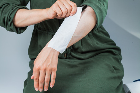 Tutorial hair removing sugaring, depilation, waxing. Closeup female hands using sugar strips for depilation. Beauty skin conceptの写真素材