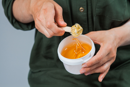 Tutorial hair removing sugaring, depilation, waxing. Closeup female hands using sugar paste. Beauty skin conceptの写真素材