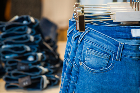 Shopping sale mall concept, denim jeans clothes on store shelvesの写真素材
