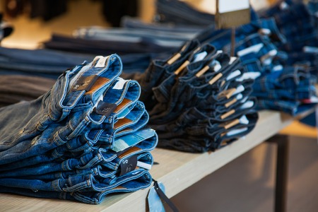 Shopping sale mall concept, denim jeans clothes on store shelvesの写真素材
