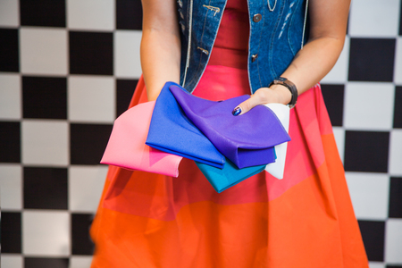 Woman with colorful fabric samples, female stylist shopper holding pieces of textile on backgroundの写真素材