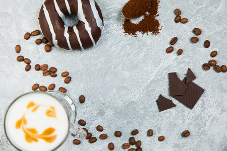 Latte coffee arabica espresso beans donuts dark chocolate background. Time for coffee and smartphone socail net concept.の写真素材