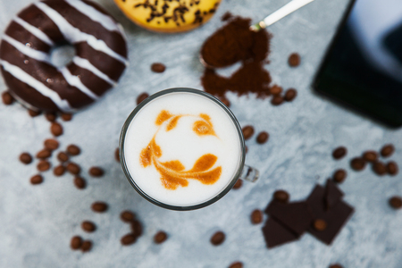 Latte coffee arabica espresso beans donuts dark chocolate background. Time for coffee and smartphone socail net concept.の写真素材