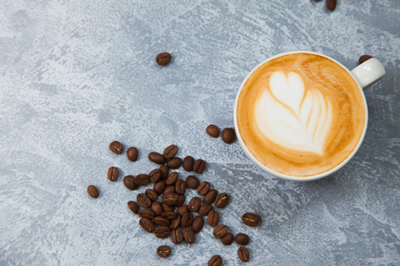 Cappuccino with coffe beans on grey background. Time for coffee concept.の写真素材