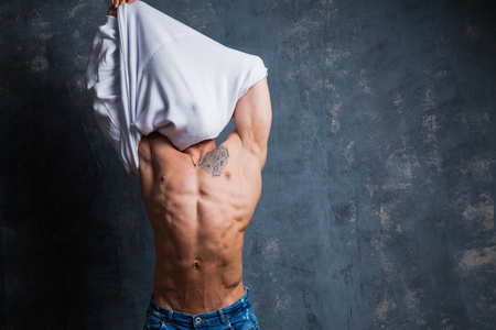 Sexy muscular male model at studio. Young budybuilder fit strong sporty man posing to camera. Guy with naked torso.の写真素材