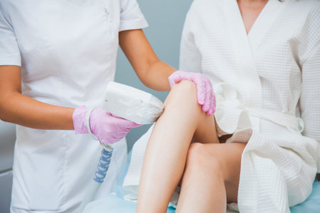 Laser hair removal, photoepilation, body and skin care concept. Young woman remove hair on legs at...