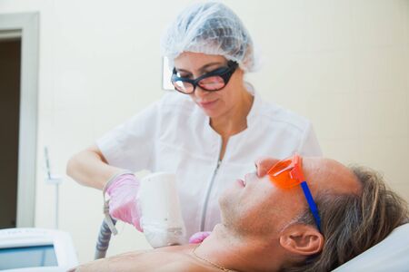 Laser hair removal procedure for young man. Male person at cosmetologist office on total body depilation. Smooth and healthy skin concept.の写真素材