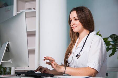 Female doctor consulting patient online from clinic office. Giving medical advise and prescriptions by internet. Pandemic coronavirus, isolation, keeping distance concept.の写真素材