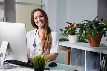 Female doctor consulting patient online from clinic office. Giving medical prescriptions by internet. Smiling woman. Pandemic coronavirus, isolation, keeping distance concept.の写真素材