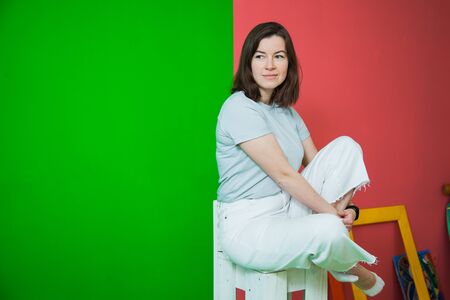 Young beautiful woman in casual clothes posing at studio, casual clothes, green and red background. Copy space for textの写真素材