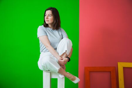 Young beautiful woman in casual clothes posing at studio, casual clothes, green and red background. Copy space for textの写真素材