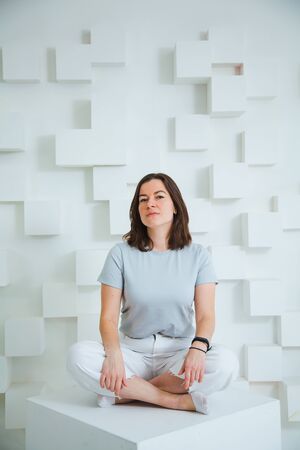 Young happy woman in casual clothes posing at studio, pastel colors, white background, casual clothes.の写真素材
