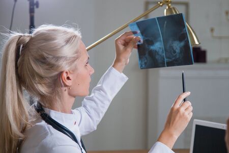 Professional female doctor practitioner exam x-ray shot at hospital clinic officeの写真素材