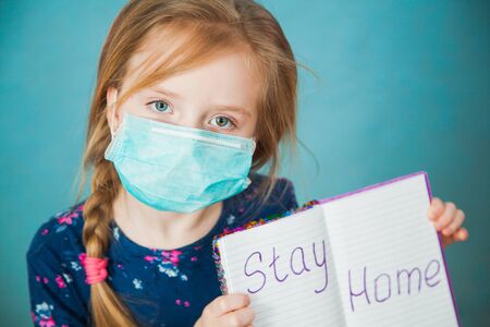 Preteen little girl in antiviral medical mask with massage stay home. Social distance, quarantine isolation concept.の写真素材