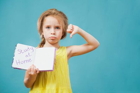 Lovely child holding handwritten message stay at home in notebook. Social distance, quarantine isolation and homeschooling concept.の写真素材