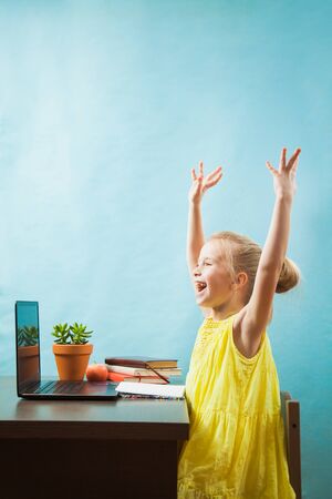 Happy preteen child in delight learn lessons at home, homeschooling with laptop. Social distance during quarantine, self-isolation, online education conceptの写真素材