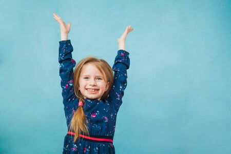 Happy delighted girl in denim jacket smile with hands up. Positive emotion, copy space for text, advertising concept.の写真素材