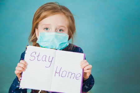 Preteen little girl in antiviral medical mask with massage stay home. Social distance, quarantine isolation, virus prevention concept. Copy space for text.の写真素材