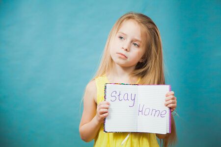 Preteen little girl in antiviral medical mask with massage stay home. Social distance, quarantine isolation, virus prevention concept. Copy space for text.の写真素材