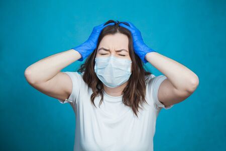 Young woman in antiviral medical mask and protective gloves feel depressed, sad and worried. Stress and fear on quarantine concept.の写真素材