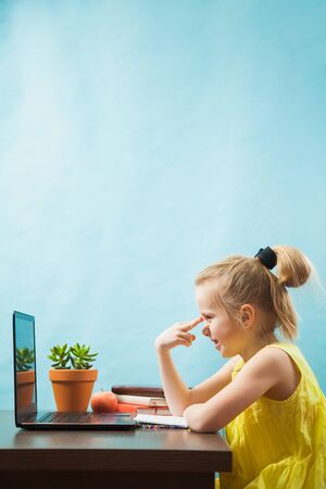 Happy preteen child learn lessons at home, homeschooling with laptop. Social distance during quarantine, self-isolation, online education conceptの写真素材