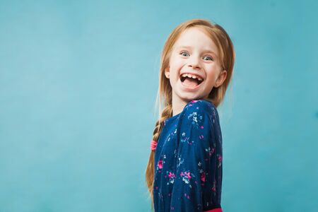 Happy delighted girl in casual blue dress smile. Positive emotion, copy space for text, advertising concept.の写真素材