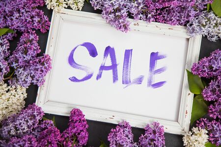 Handwritten word sale in white frame lay in lilac blossom. Shopping concept.の写真素材