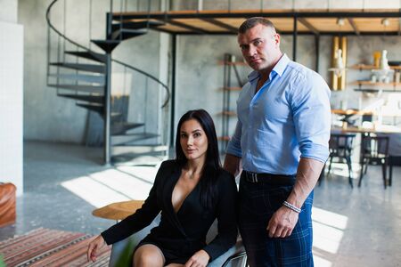 Sexy stylish couple of business people at home studio. Two beautiful models pose to camera.の写真素材