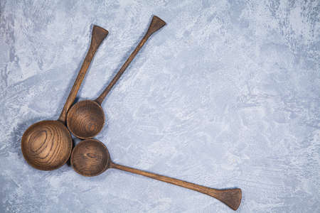 Hand carved wooden spoons arranged on gray background.. Top view flat lay.の写真素材