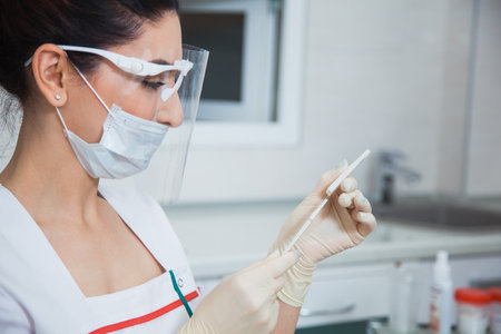 Female stomatologist ready for dental surgery, holding scalpel. Toothcare concept. Dentist at clinic office. Toothcare conceptの写真素材