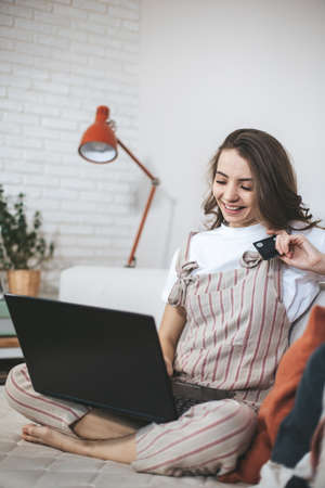 Young millennial woman shopping online at home.の写真素材