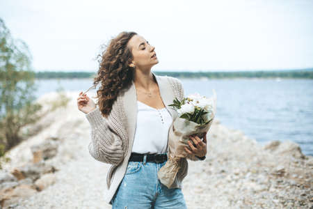 Young beautiful woman with flowers bouquetの写真素材