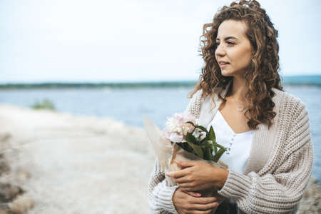 Young beautiful woman with flowers bouquetの写真素材