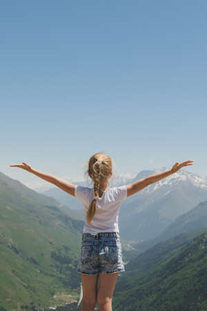 Happy preteen girl hiking on caucasian mountains in summer.の写真素材