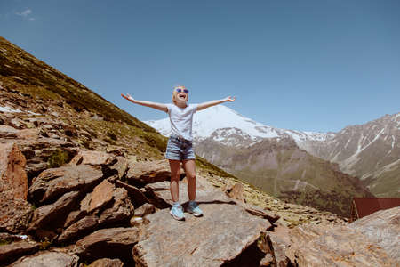 Happy preteen girl hiking on caucasian mountains in summer.の写真素材