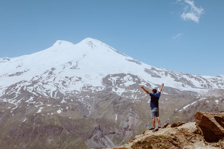 Man stand on rocky mountain and look at snowy peak of Elbrus.の写真素材