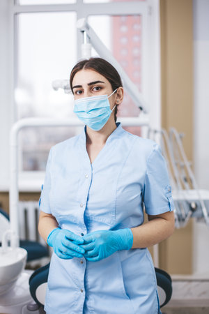 Professional young dentist posing near dental equipment in a dental clinic. Portrait of female doctor.の写真素材