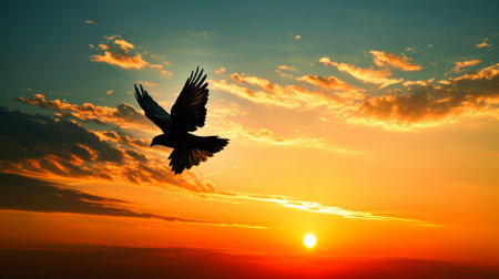The concept of freedom, a bird in flight against a golden hour sky.の素材