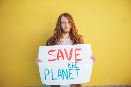 Environmentalist is holding a sign with a handwritten message promoting environmental awareness and the importance of protecting our planetの写真素材