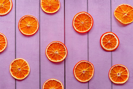 Slices of orange on a purple wooden background. top view.の写真素材