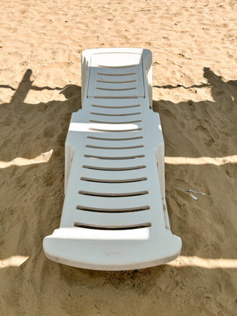 Plastic White Lounger on the Sandの写真素材