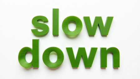 Green "slow down" lettering on a white backgroundの素材