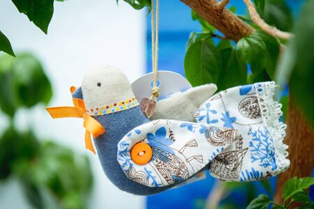 toy blue bird made of fabric on a tree, handmade
