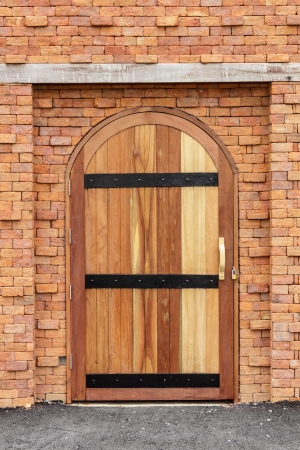 Strong wooden door on old brick wall の写真素材