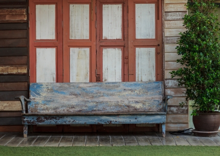 Old chair with the background of old wooden house.の写真素材